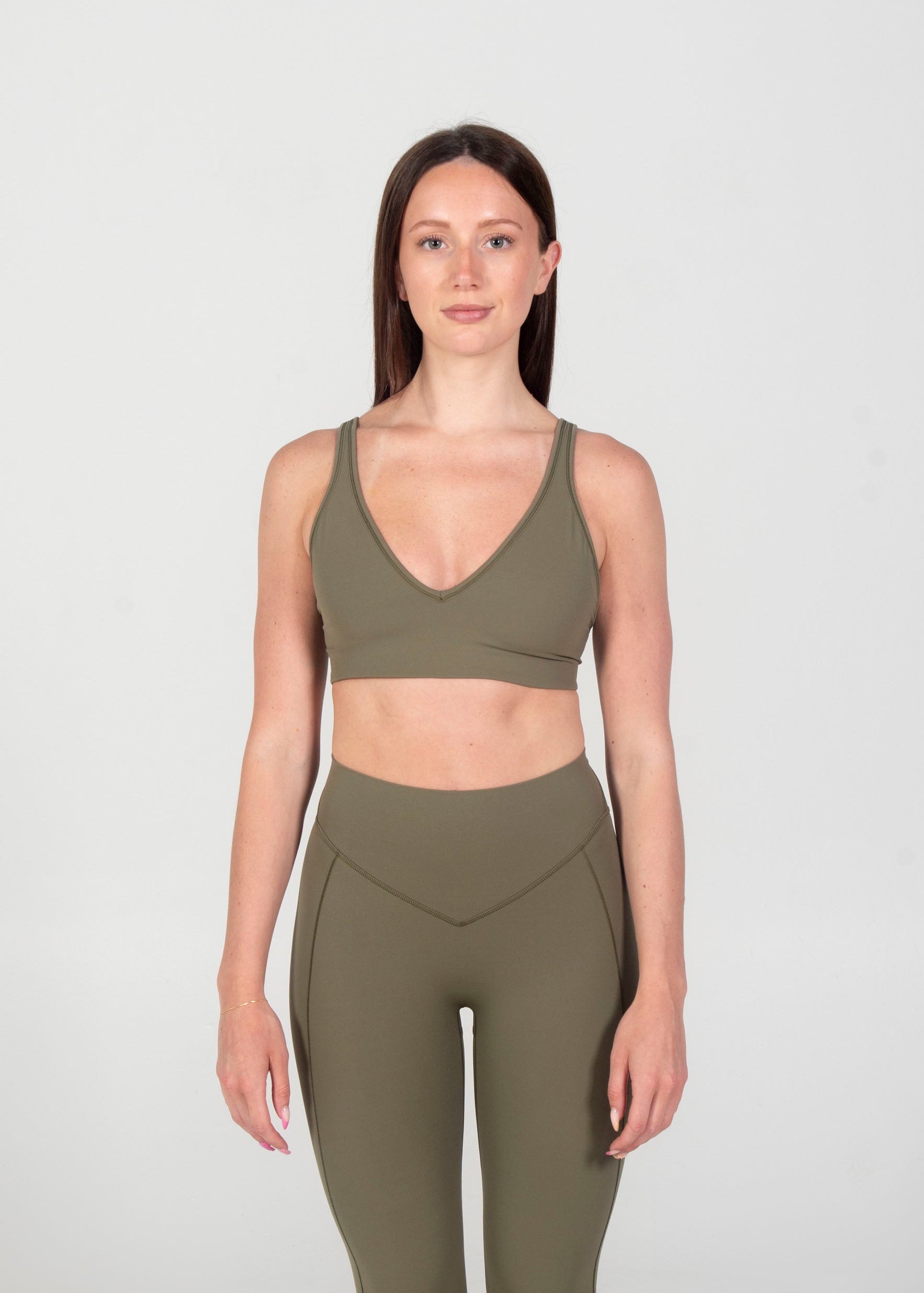 Woman wearing a green athletic outfit on a white background