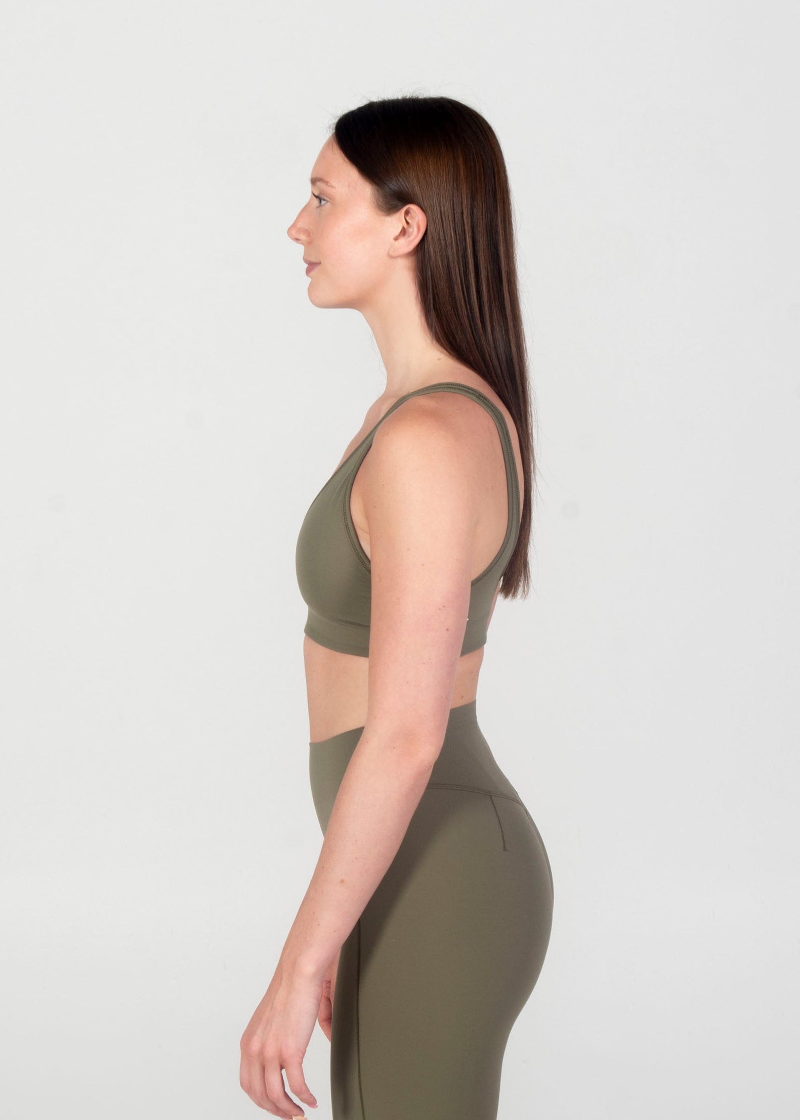 Woman wearing a green athletic outfit on a white background