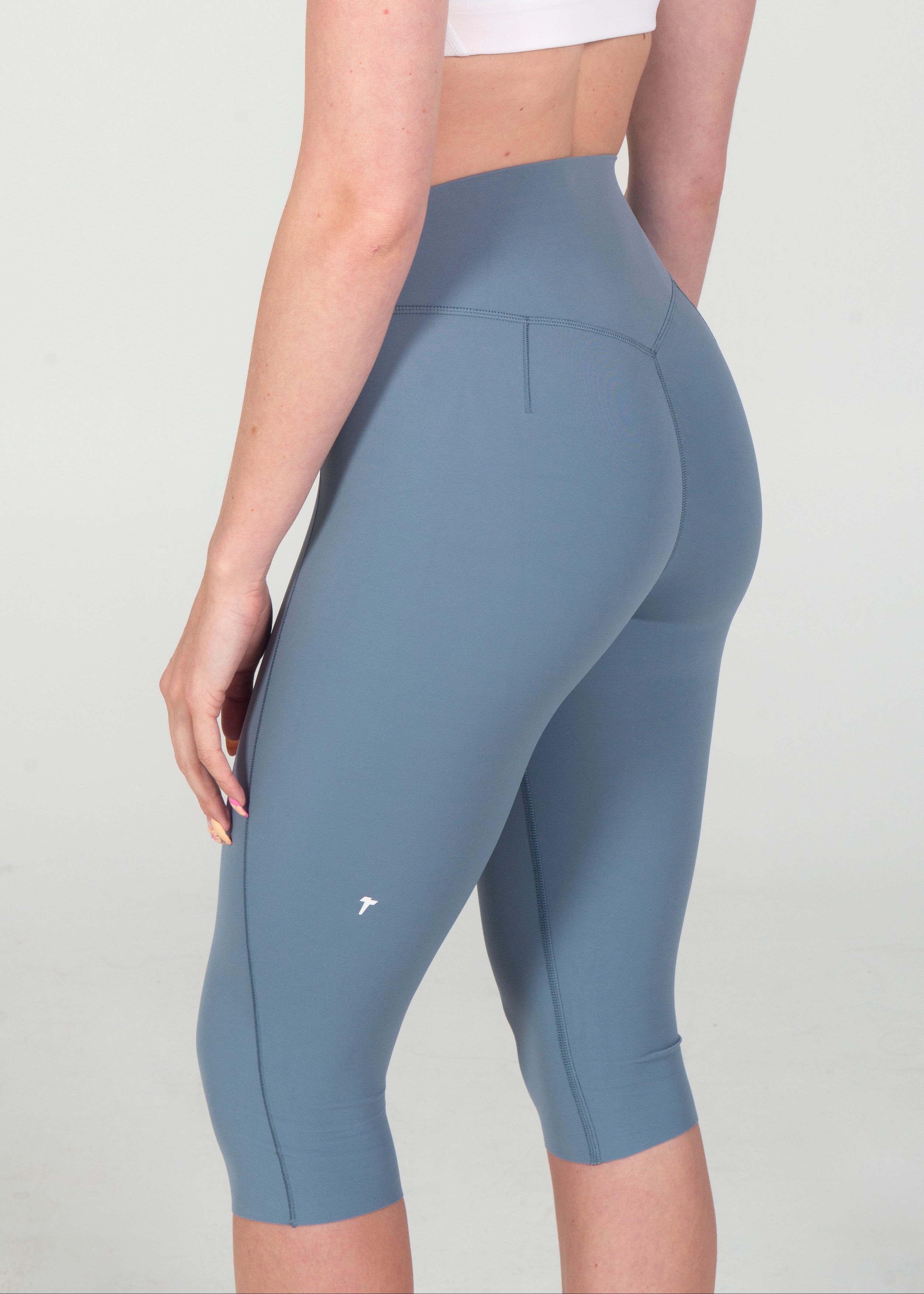 Person wearing blue athletic leggings on a plain background