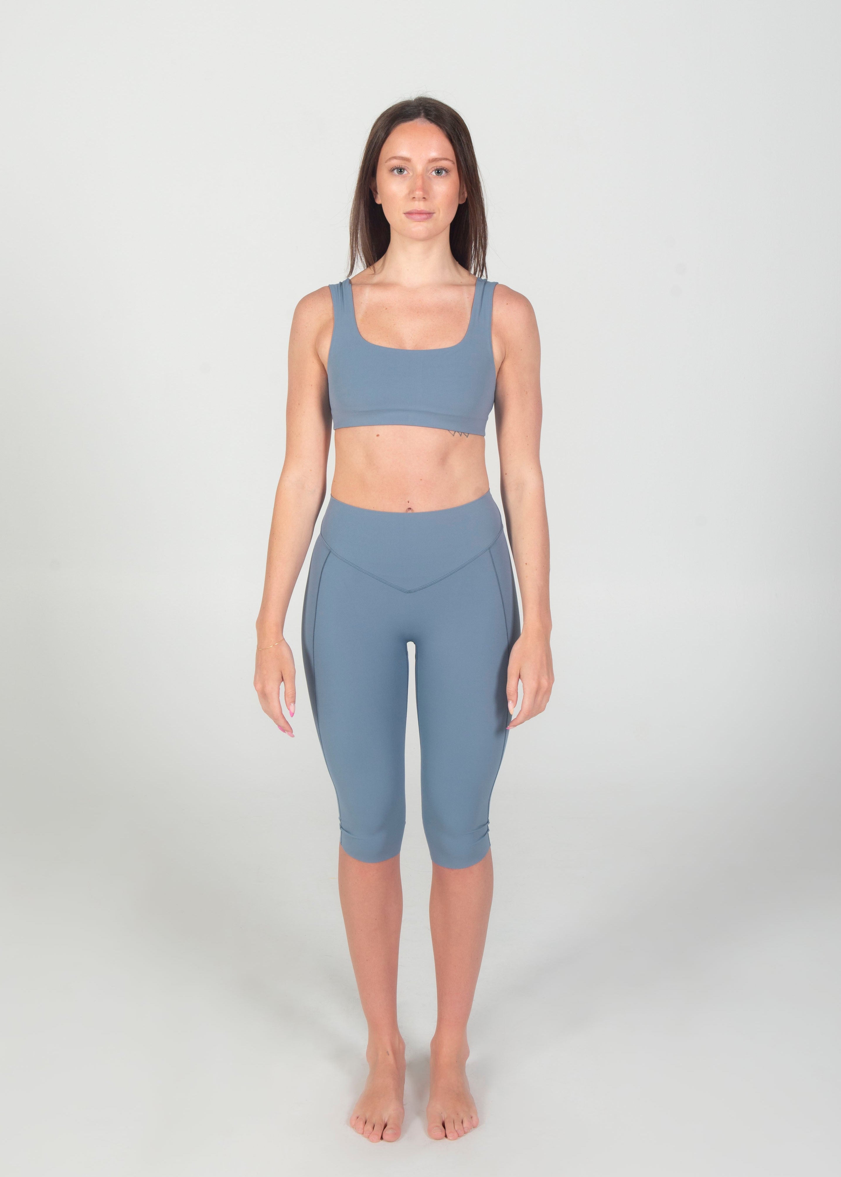 Woman wearing a blue athletic outfit on a white background