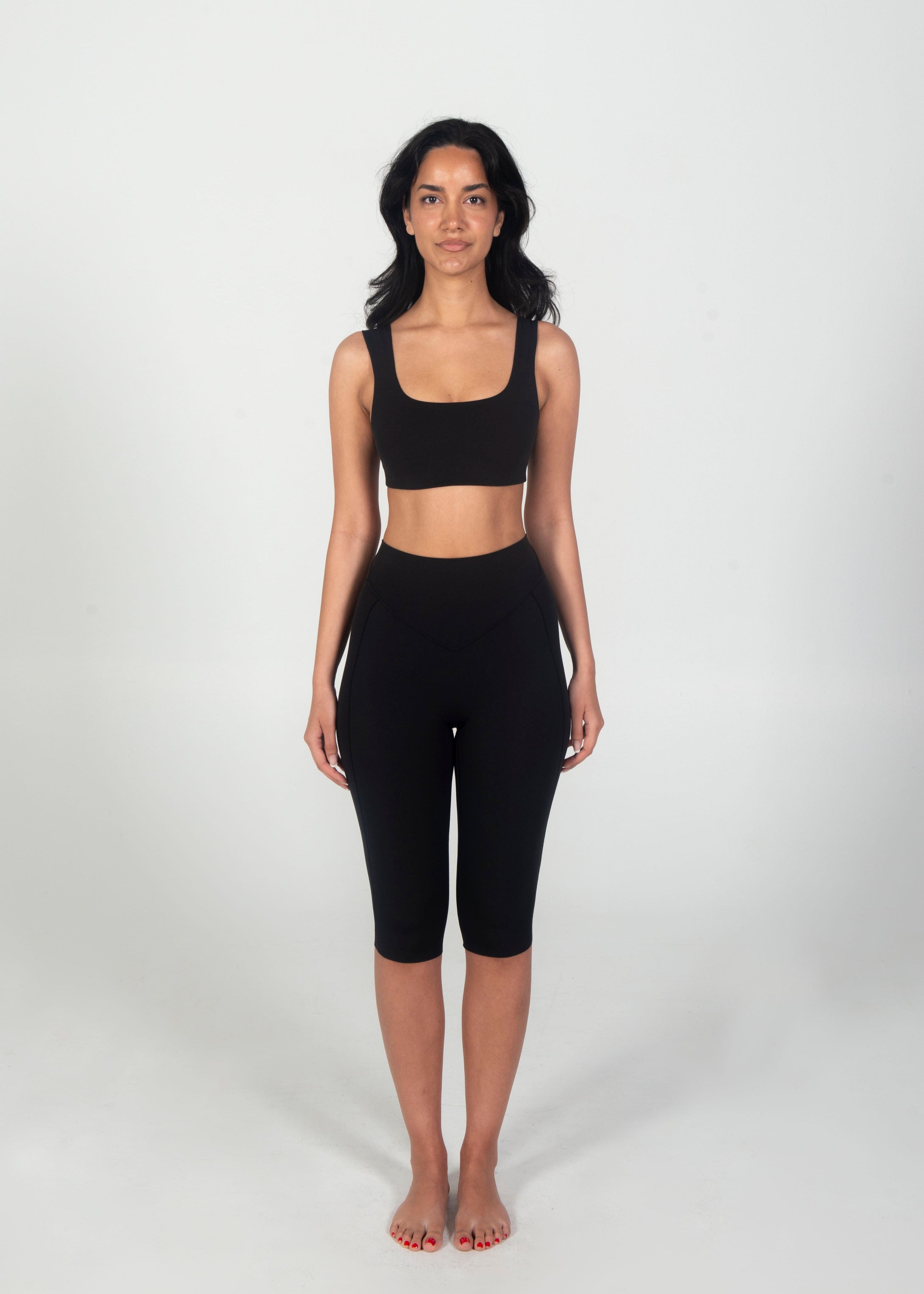 Woman wearing a black athletic outfit on a white background