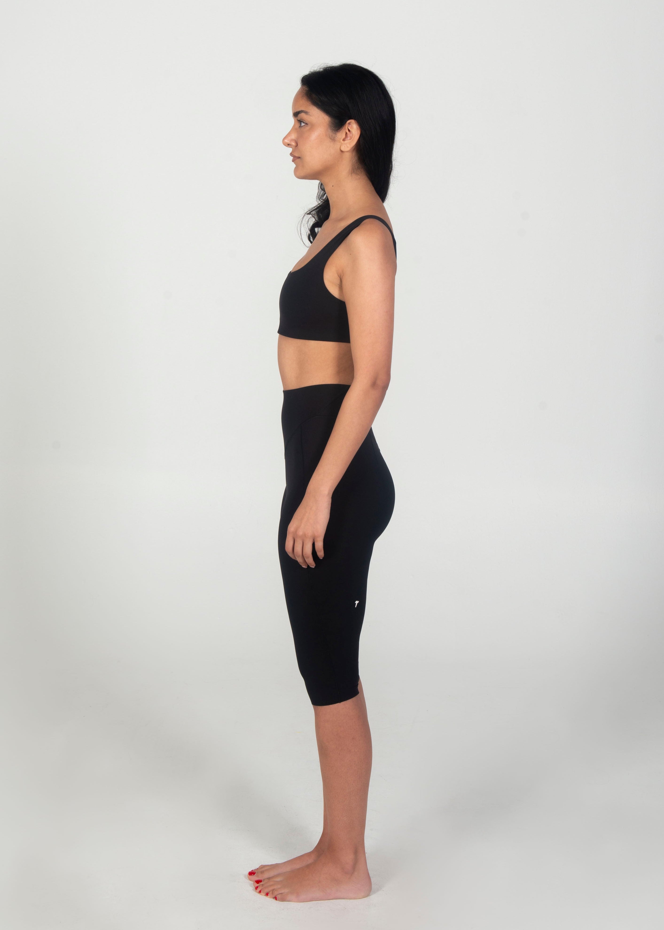 Woman wearing a black athletic outfit on a white background