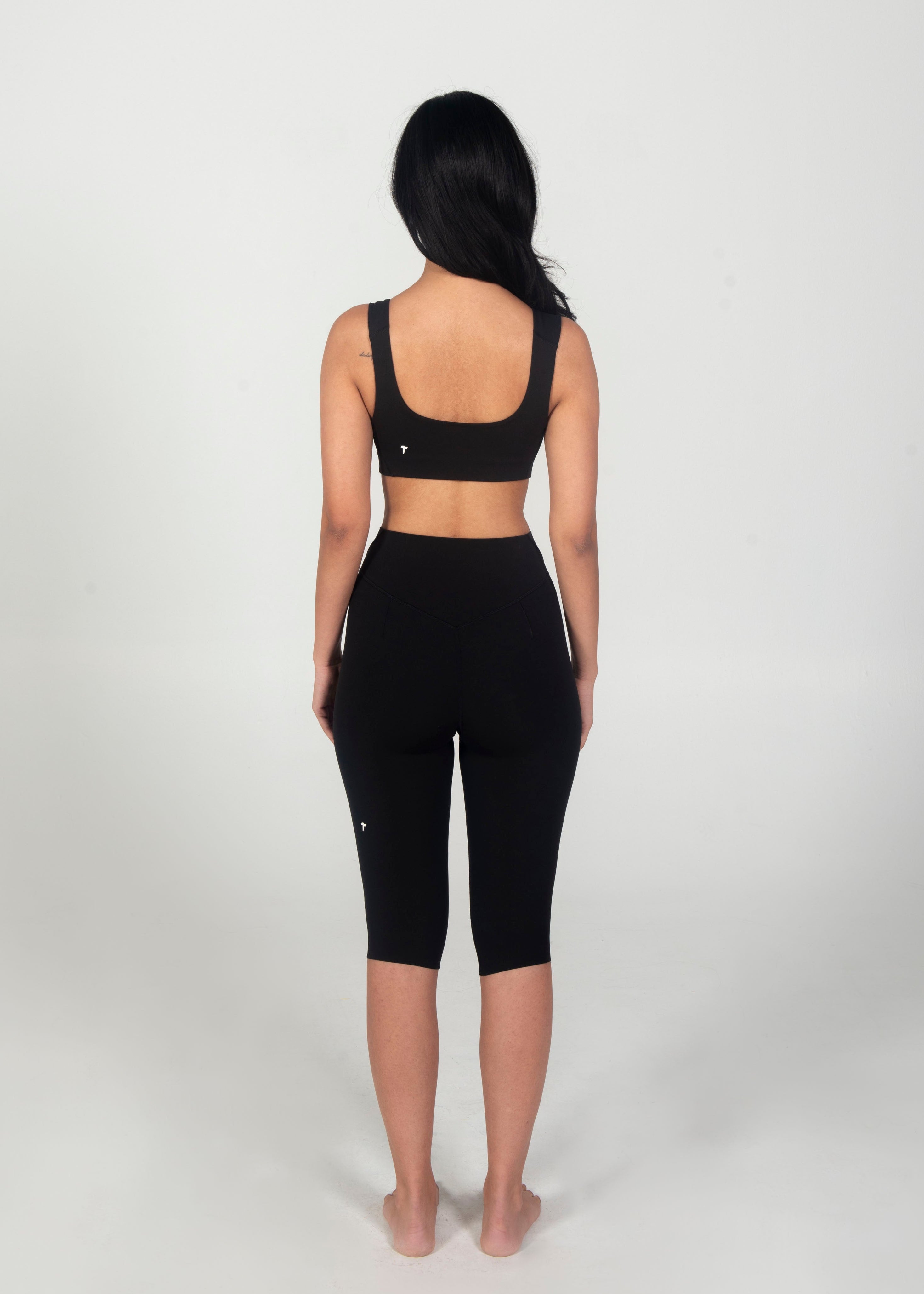 Person wearing a black athletic outfit on a white background