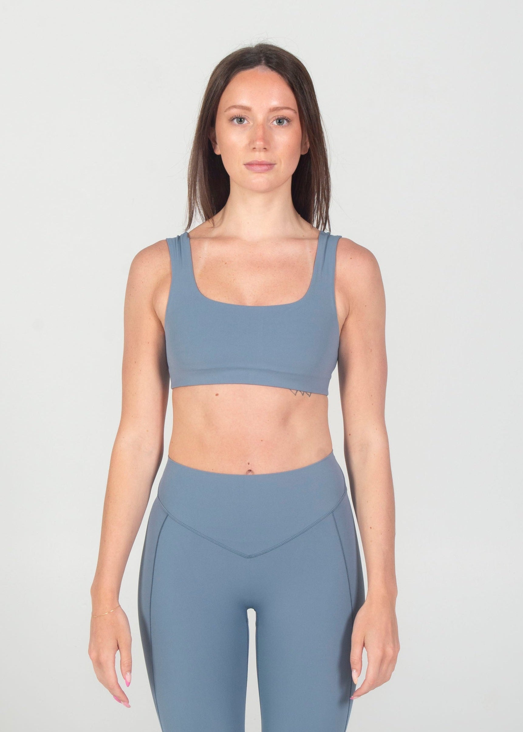 Woman wearing a blue athletic outfit on a white background