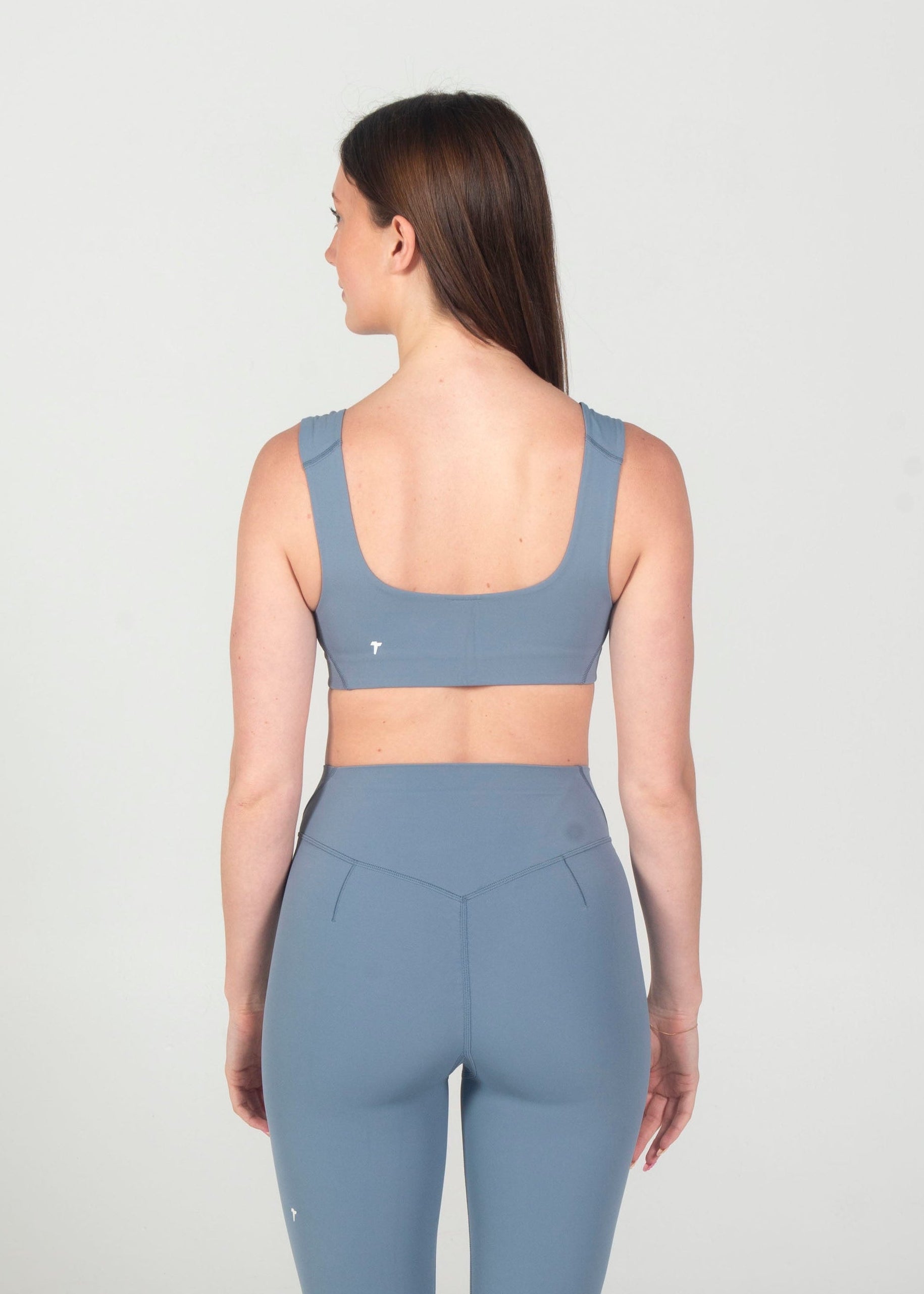 Woman wearing a blue athletic outfit on a white background