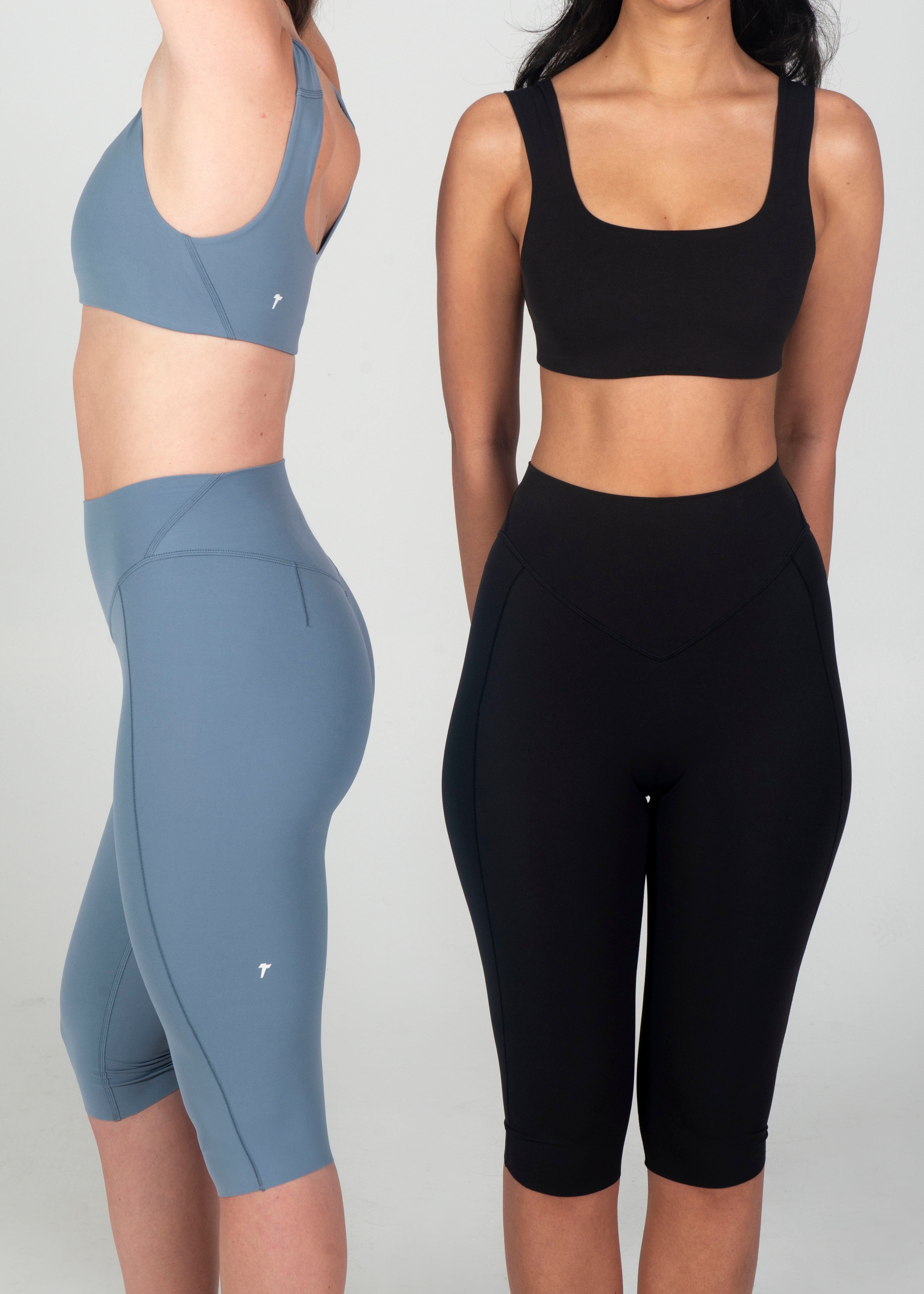Two people wearing athletic wear, one in blue and the other in black, on a plain background.